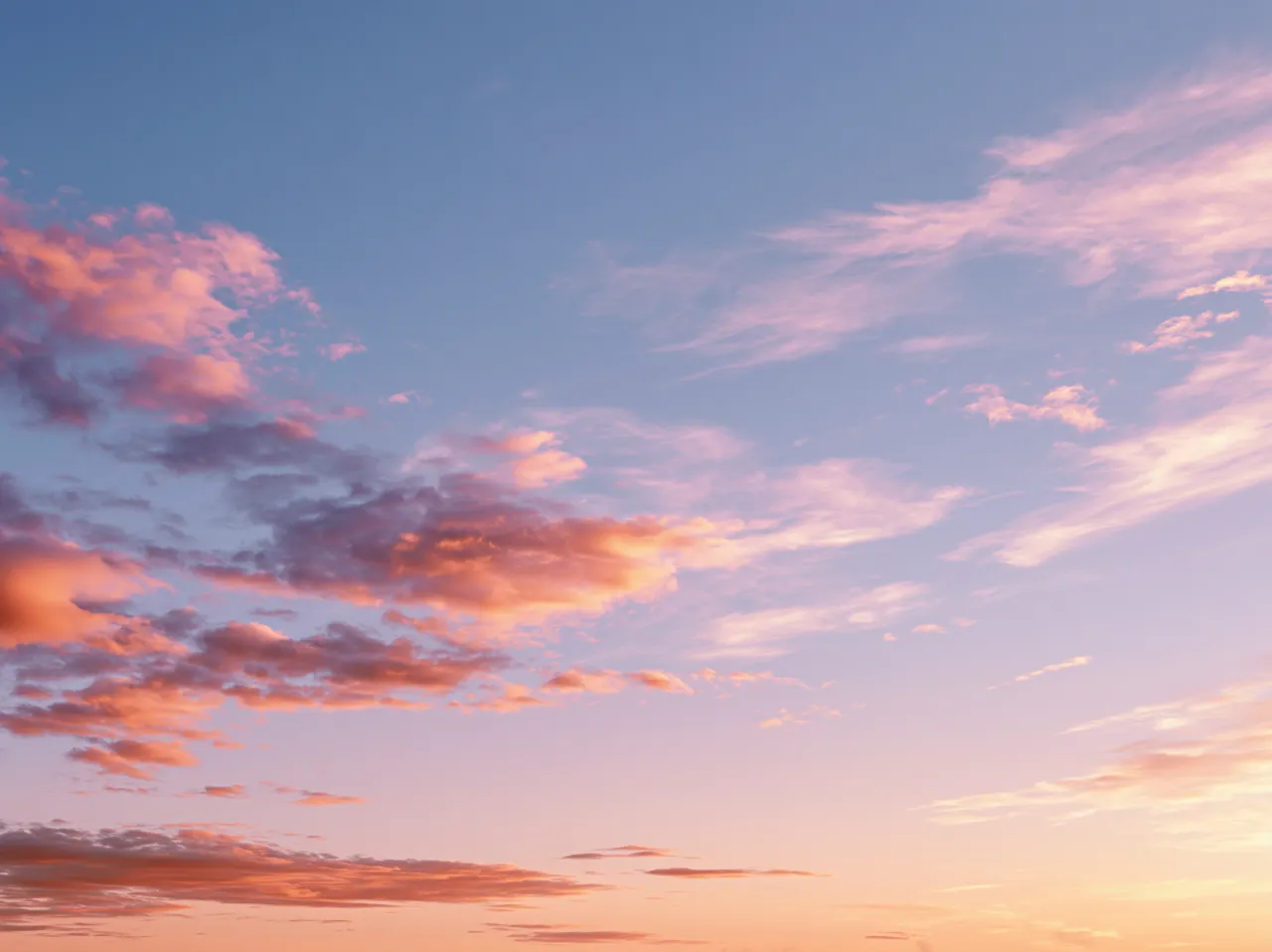 A soft sunset sky with coral and lavender clouds